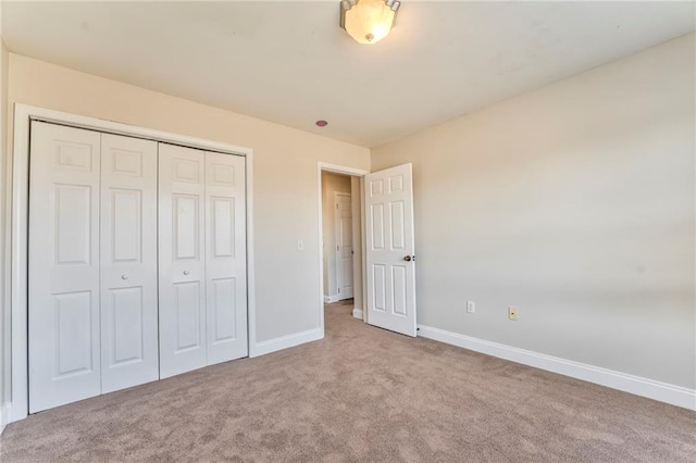 unfurnished bedroom featuring light carpet and a closet