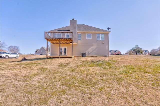 rear view of property with central AC unit, a deck, a lawn, and french doors