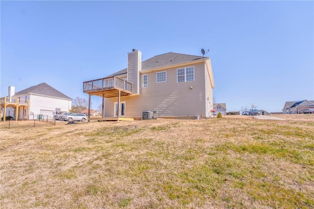 back of property featuring a wooden deck, a lawn, and central air condition unit