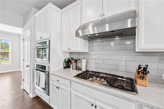 350 Provenance Dr, Atlanta, GA 30328 - kitchen with under cabinet range hood, appliances with stainless steel finishes, white cabinets, tasteful backsplash, and light stone counters