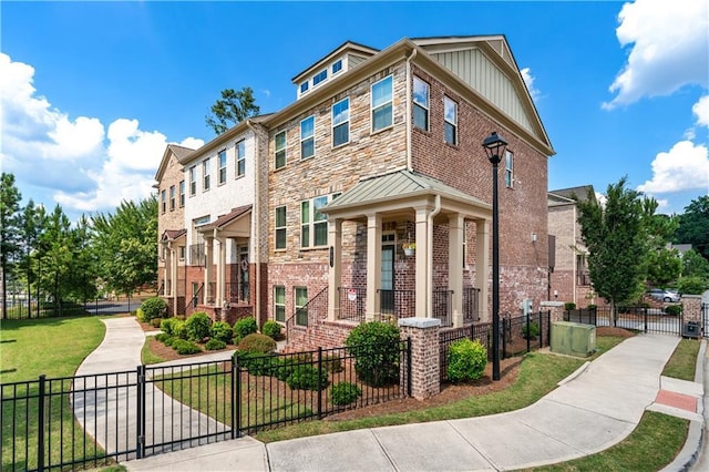 350 Provenance Dr, Atlanta, GA 30328 - view of front of house featuring a fenced front yard, brick siding, a gate, and a standing seam roof