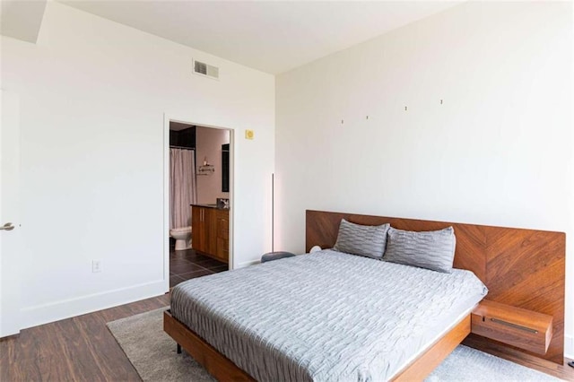 bedroom with dark wood-type flooring, visible vents, and baseboards