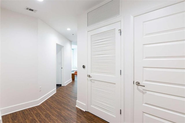 hallway with visible vents, baseboards, dark wood-style flooring, and recessed lighting