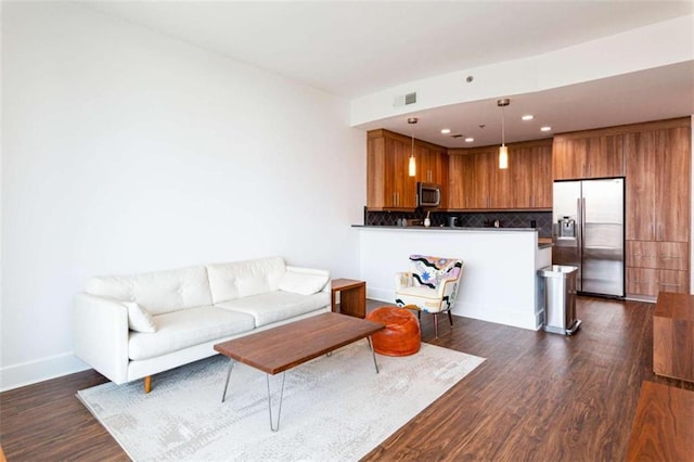 living room with baseboards, visible vents, dark wood finished floors, and recessed lighting