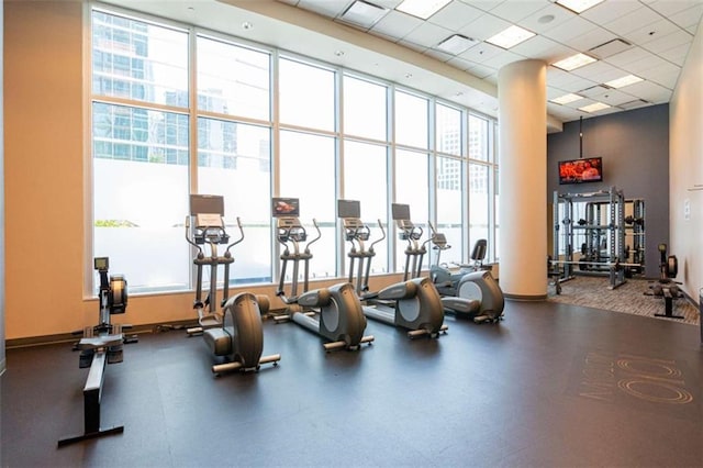 gym with plenty of natural light, a high ceiling, visible vents, and a drop ceiling