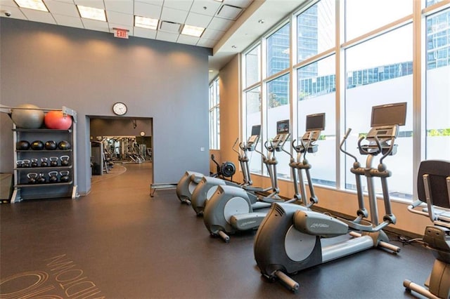 gym with a paneled ceiling and a towering ceiling