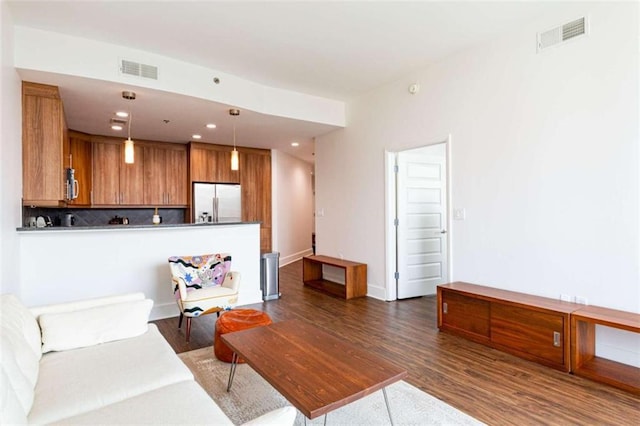 living room with dark wood-style floors, visible vents, and recessed lighting