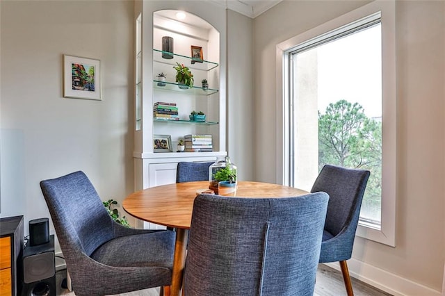 dining area featuring ornamental molding, baseboards, and wood finished floors