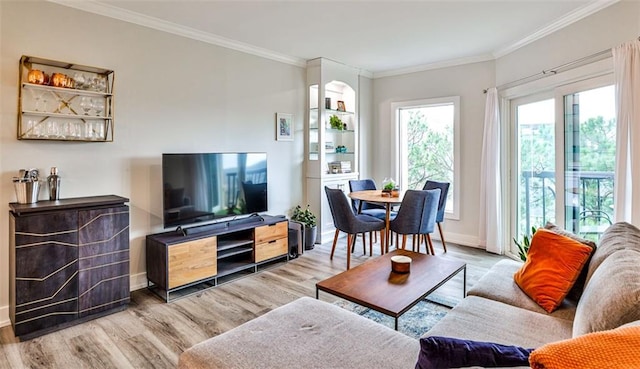 living room with crown molding, baseboards, and wood finished floors