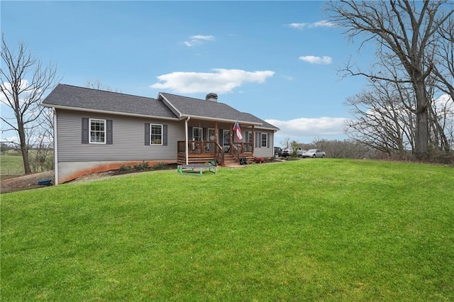 rear view of house with a wooden deck, a chimney, and a yard