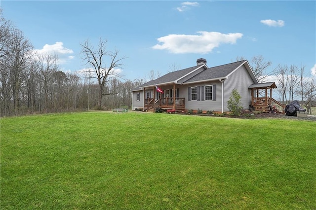 view of property exterior with a chimney, a deck, and a lawn