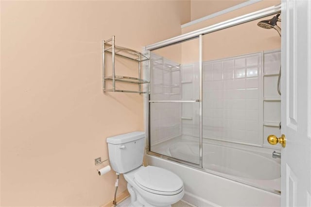 bathroom featuring toilet and bath / shower combo with glass door