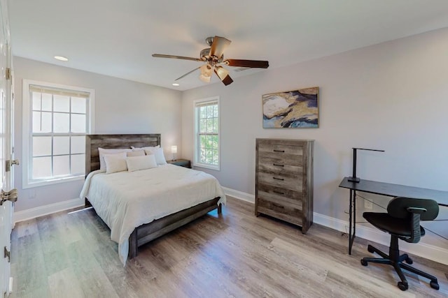 bedroom with baseboards, wood finished floors, and a ceiling fan