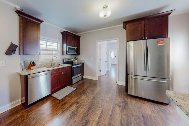 kitchen with dark wood finished floors, appliances with stainless steel finishes, light stone counters, and a sink