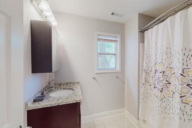 bathroom with vanity, a shower with shower curtain, baseboards, visible vents, and tile patterned floors