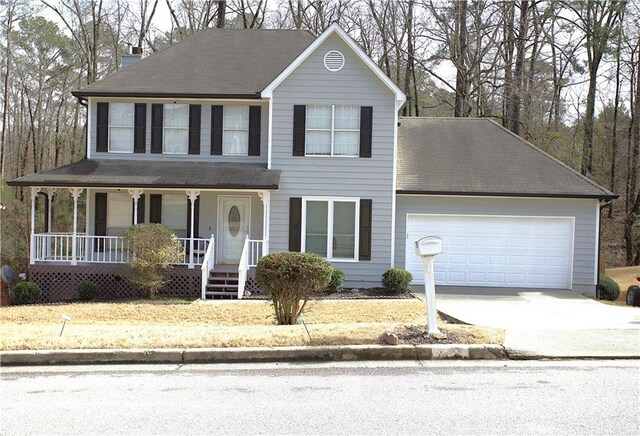 colonial house with covered porch, a front lawn, and a garage