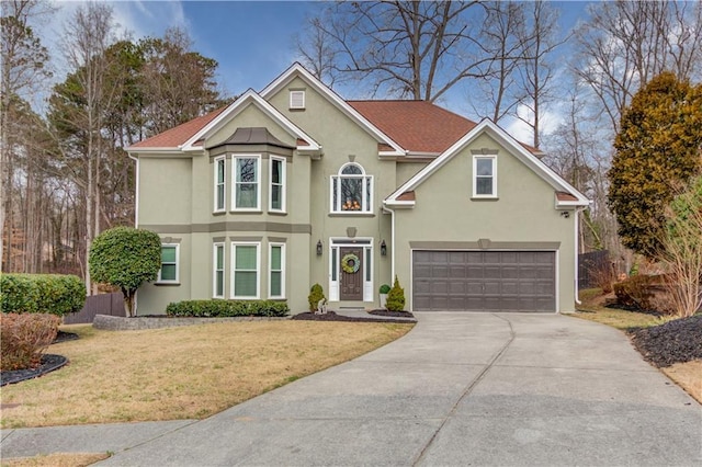 view of property featuring a garage and a front lawn