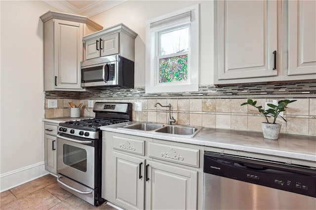 kitchen featuring decorative backsplash, appliances with stainless steel finishes, light countertops, and a sink