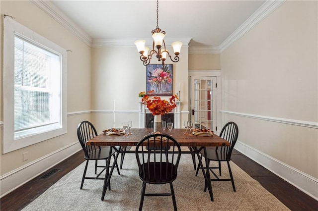 dining room with baseboards, a chandelier, wood finished floors, and crown molding