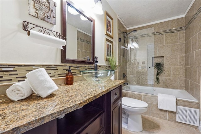 bathroom with tile walls, visible vents, tiled shower / bath combo, vanity, and tile patterned flooring