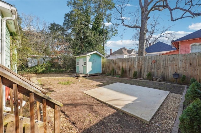 view of yard with an outbuilding, a patio area, a fenced backyard, and a storage unit