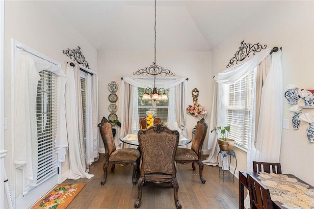 dining room featuring a chandelier, lofted ceiling, and hardwood / wood-style flooring