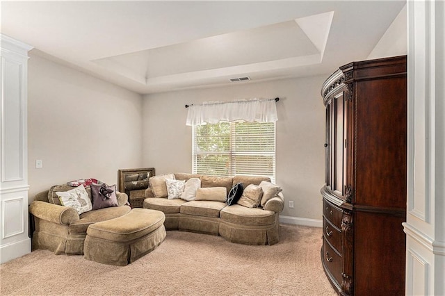 living room with carpet flooring, ornate columns, and a tray ceiling