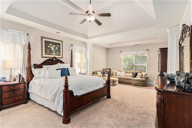 bedroom with ceiling fan, light carpet, ornate columns, and a raised ceiling