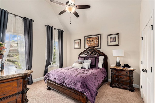 carpeted bedroom featuring lofted ceiling, multiple windows, ceiling fan, and a closet