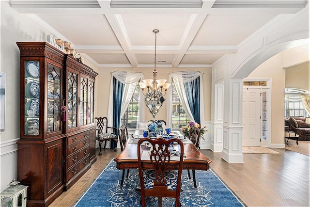 dining area with ornamental molding, beam ceiling, coffered ceiling, hardwood / wood-style flooring, and a chandelier