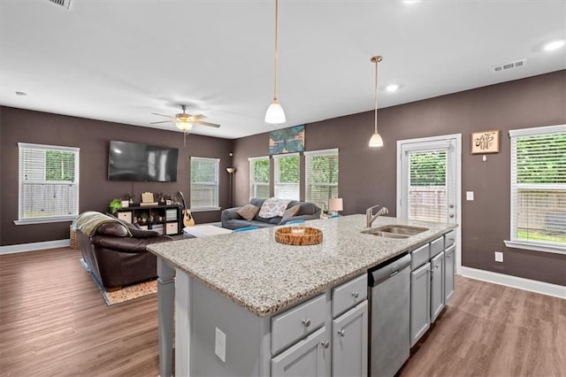 560 Vandenburg Dr, Villa Rica, GA 30180 - kitchen with stainless steel dishwasher, light wood finished floors, hanging light fixtures, a ceiling fan, and a center island with sink