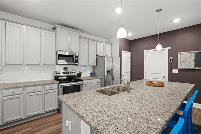 560 Vandenburg Dr, Villa Rica, GA 30180 - kitchen featuring appliances with stainless steel finishes, dark wood-type flooring, a center island with sink, and backsplash