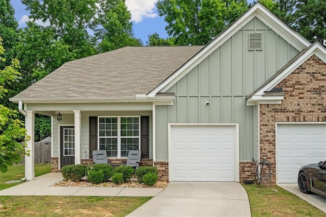 560 Vandenburg Dr, Villa Rica, GA 30180 - view of front of home featuring board and batten siding, roof with shingles, covered porch, and brick siding