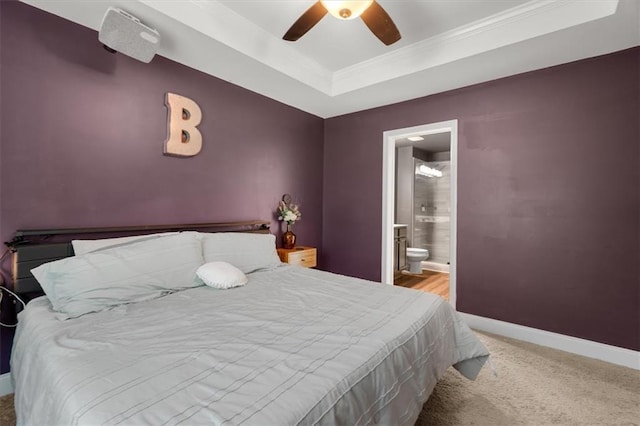 560 Vandenburg Dr, Villa Rica, GA 30180 - bedroom featuring carpet flooring, a tray ceiling, crown molding, connected bathroom, and ceiling fan