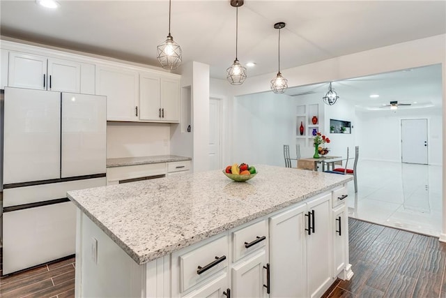 kitchen featuring white cabinetry, white fridge, a center island, and decorative light fixtures