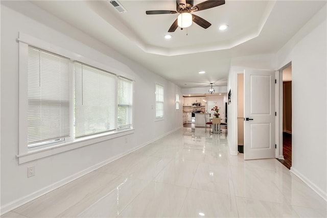 hall featuring a raised ceiling