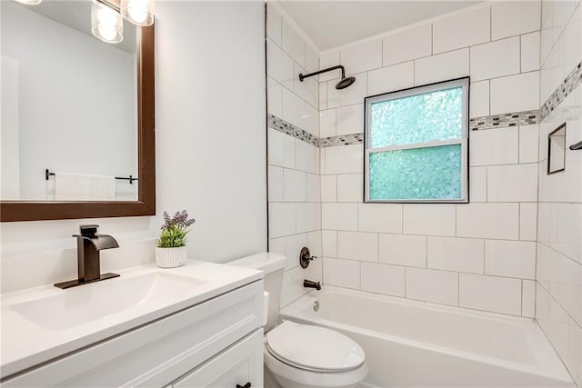 full bathroom featuring vanity, tiled shower / bath, and toilet