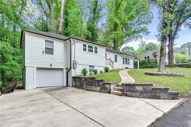 rear view of house featuring a garage and a yard