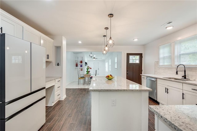 kitchen featuring sink, white cabinetry, white refrigerator, stainless steel dishwasher, and a kitchen island