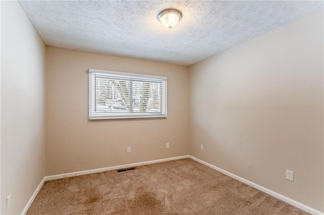 empty room featuring carpet and a textured ceiling