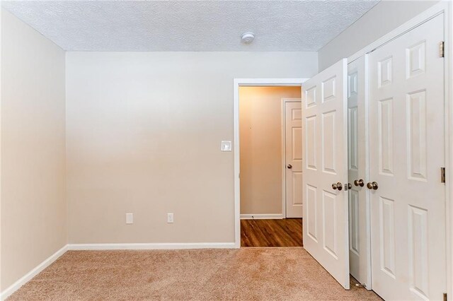 carpeted spare room with a textured ceiling