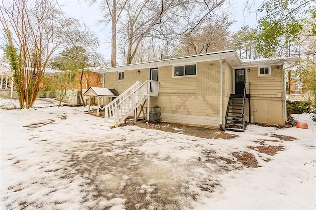 snow covered rear of property with cooling unit