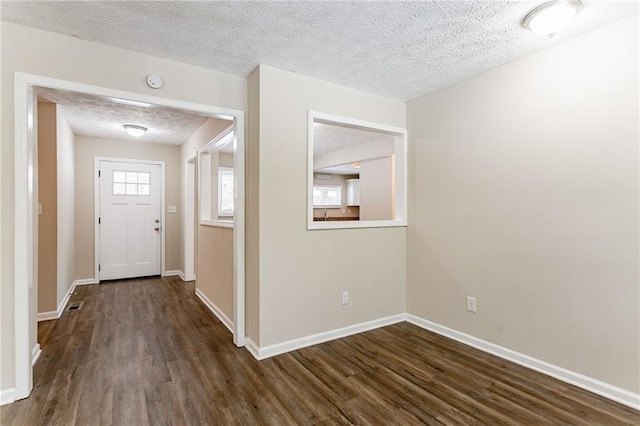 entryway with dark wood-type flooring and a textured ceiling