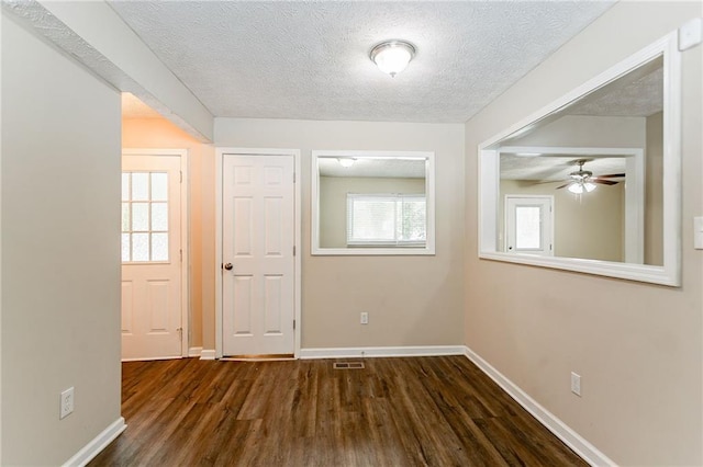 spare room with a textured ceiling and dark hardwood / wood-style flooring