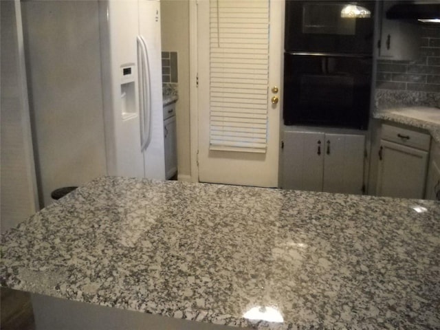 kitchen with tasteful backsplash, white refrigerator with ice dispenser, and double oven