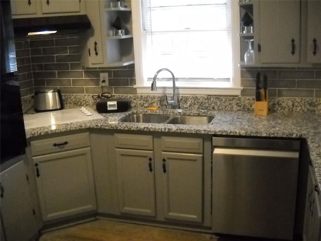 kitchen with dishwasher, sink, backsplash, and light stone counters