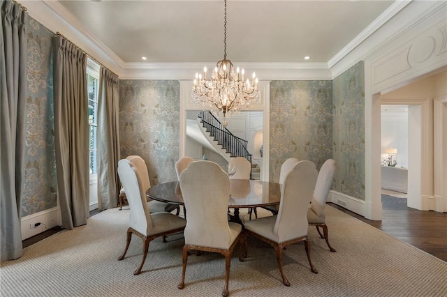 dining room with ornamental molding, hardwood / wood-style floors, and a chandelier