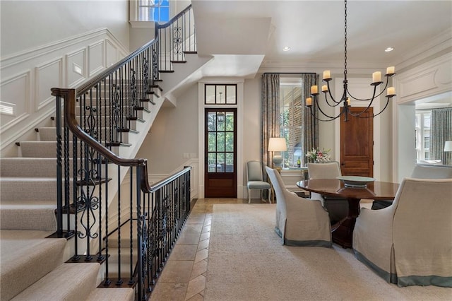 dining area with stairway, a wainscoted wall, recessed lighting, an inviting chandelier, and a decorative wall