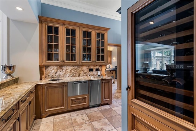 interior space featuring stainless steel fridge, light stone countertops, backsplash, ornamental molding, and sink