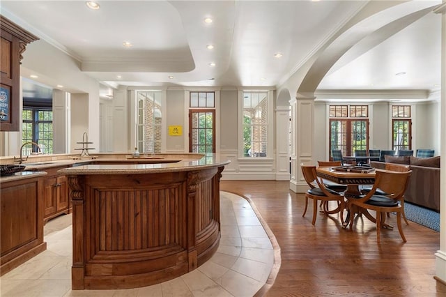 interior space with ornamental molding, a healthy amount of sunlight, ornate columns, and light hardwood / wood-style floors